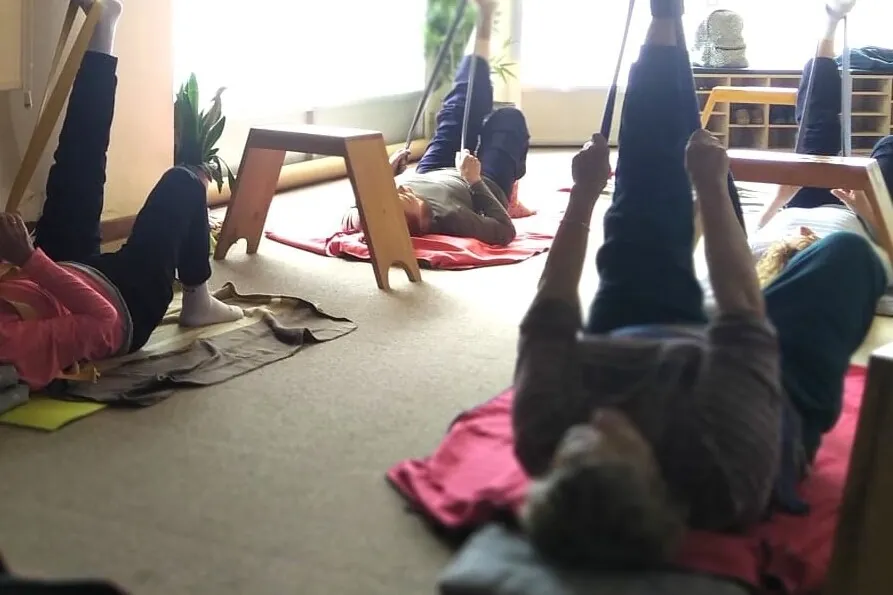 Grupo practicando gimnasia suave con ejercicios adaptados